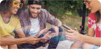 A group of happy young people are sitting and looking at their smartphones.