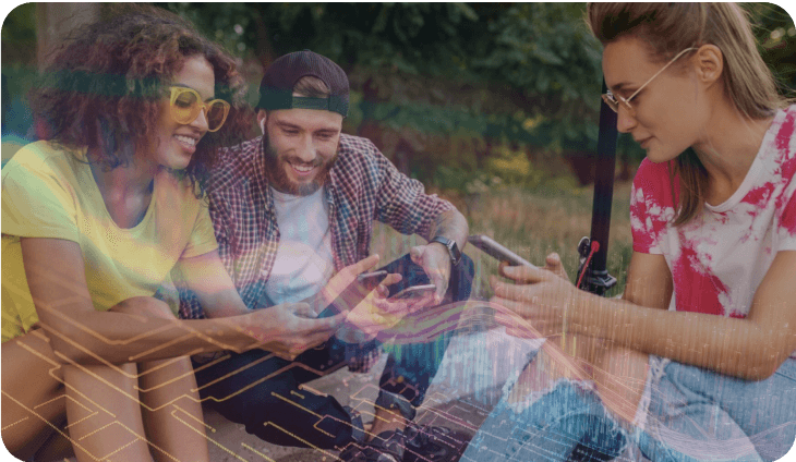 A group of happy young people are sitting and looking at their smartphones.