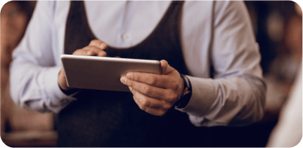 A waiter is working with a tablet.